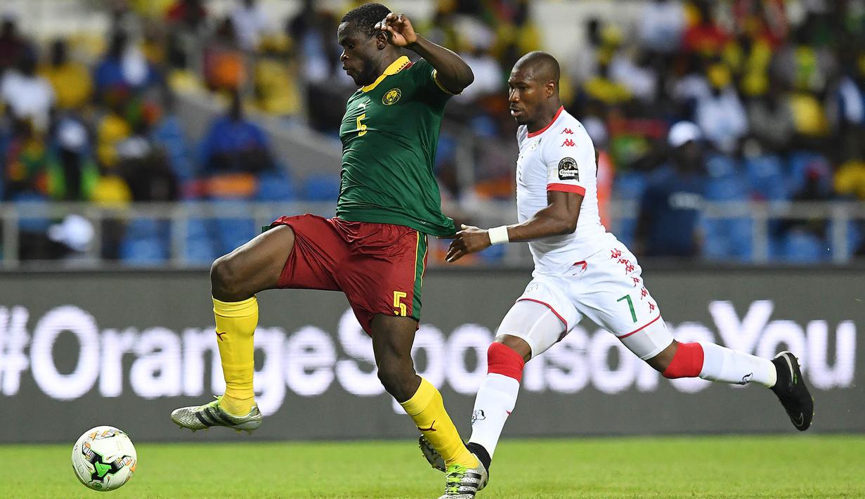 Bek Kamerun, Michael Ngadeu-Ngadjui, berhasil melewati gelandang Burkina Faso, Prejuce Nakoulma. Pada laga ini Kamerun menggunakan formasi 4-2-3-1, sementara Burkina Faso memakai skema 4-4-2. (AFP/Gabriel Bouys)