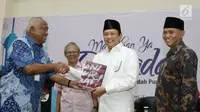 Mantan Ketua KPK Taufiqurrahman Ruki memberikan buku ke Ketua DPR RI Bambang Soesatyo saat peluncuran buku "14 Tahun Perjalanan KPK" di Gedung KPK, Jakarta (23/5). (Liputan6.com/Herman Zakharia)