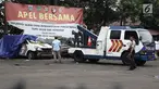 Petugas Ditlantas Polda Metro Jaya membawa mobil dinas polisi di Mapolsek Ciracas, Jakarta, Rabu (12/12). Ditlantas Polda Metro Jaya mengevakuasi sejumlah mobil yang rusak akibat penyerangan Polsek Ciracas. (Liputan6.com/Herman Zakharia)