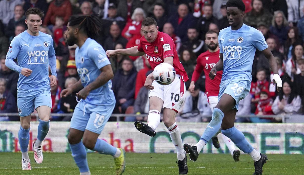 Aksi dari pemain Wrexham, Paul Mullin (tengah), saat melawan Boreham Wood dalam pertandingan English National League yang berlangsung di The Racecourse Ground, Wales, Sabtu (22/4/2023) WIB. (AP/PA/Martin Rickett)