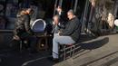 Orang-orang duduk dan bermain backgammon di depan sebuah toko di pasar di distrik Fatih Istanbul, Turki, Selasa, 3 Januari 2023. Menurut data resmi, harga konsumen naik 1,2% di Desember secara bulanan, dibandingkan dengan 2,9% pada November. (AP Photo/Khalil Hamra)