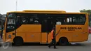 Petugas menyapu di dekat bus sekolah yang parkir di Terminal Pasar Minggu, Jakarta, Senin (26/10). Gubernur DKI Basuki Tjahaja Purnama berencana menghapus bus sekolah. Sebagai gantinya, pelajar digratiskan naik Transjakarta. (Liputan6.com/Gempur M Surya)