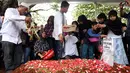 Keluarga dan kerabat menaburkan bunga di atas makam Yanni Libels di TPU Tanah Kusir, Jakarta, Kamis (26/3/2015). Yanni Libels meninggal pada hari Rabu (25/3) di Bandara Soekarno Hatta. (Liputan6.com/Panji Diksana)
