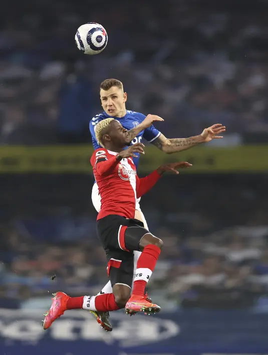 Bek Everton, Lucas Digne berebut bola udara dengan pemain Southampton, Moussa Djenepo pada pertandingan lanjutan Liga Inggris di Goodison Park di Liverpool, Inggris, Selasa (2/3/2021). Everton menang tipis atas Southampton 1-0. (Clive Brunskill / Pool via AP)