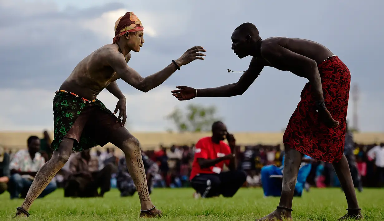 Dua pegulat bertarung sengit dalam Kompetisi Gulat Nasional Sudan Selatan di Stadion Juba, Sudan (20/4). Kompetisi ini diikuti oleh sejumlah atlet dari berbagai daerah di Sudan. (CARL DE SOUZA / AFP)