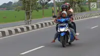 Pemudik sepeda motor dengan membawa anak melintasi Jalur Pantura Cirebon, Jawa Barat, Kamis, (29/6). Memasuki H+4 Lebaran jalur Pantura Cirebon mengarah ke Jakarta mulai dipadati pemudik pengguna kendaraan bermotor roda dua (Liputan6.com/Helmi Afandi)