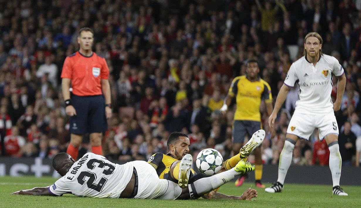 Pemain Basel, Eder Balanta (kiri) menghadang laju pemain Arsenal, Theo Walcott pada laga grup A Liga Champions di Emirates stadium, London, Kamis (29/9/2016)dini hari WIB. (AP/Alastair Grant)