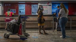 Penumpang menunggu di loket tiket di bandara Johannesburg OR Tambo, Afrika Selatan (29/11/2021). Banyak negara memberlakukan larangan penerbangan terhadap negara-negara Afrika selatan karena kekhawatiran atas varian baru (Covid-19) Omicron. (AP/Jerome Delay)