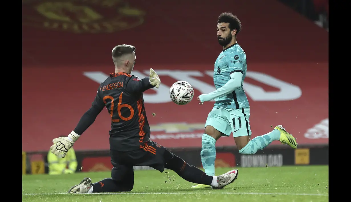 Pemain Liverpool, Mohamed Salah (kanan) berhasil mengecoh kiper dan menjebol gawang Manchester United pada laga babak keempat FA Cup 2020-21 di Old Trafford, Senin (25/01/2021). (Foto: AP/Pool/Martin Rickett)