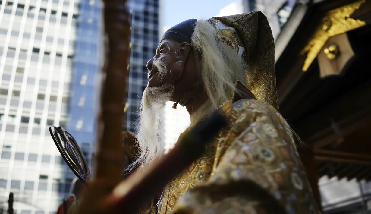 Seniman menggenakan topeng Jurojin, Dewa umur panjang dan salah satu dari Tujuh Dewa Keberuntungan, melakukan upacara ritual Festival Konpira Pertama di kuil Kotohiragu di distrik bisnis Toranomon di Tokyo (10/1/2020). (AP Photo/Eugene Hoshiko)