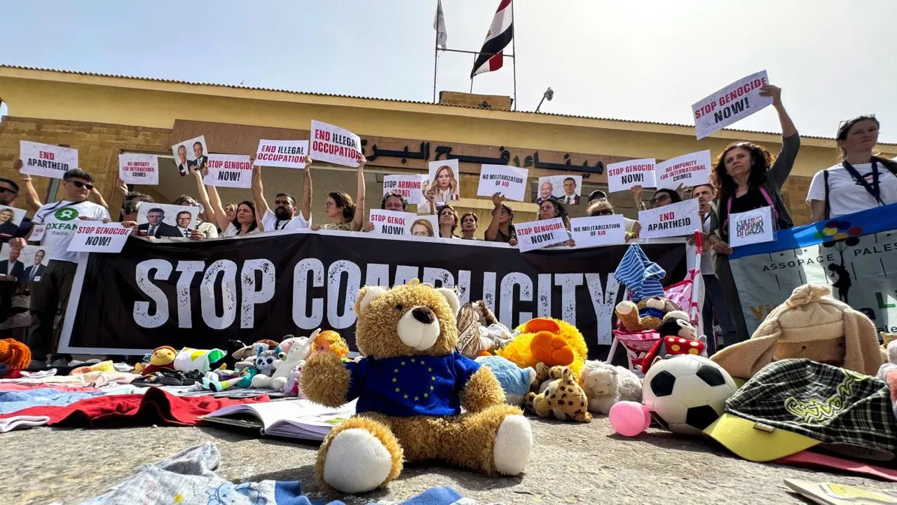 Anggota parlemen Italia dan Eropa memegang plakat selama protes di depan sisi Mesir dari perbatasan Rafah, menyerukan diakhirinya perang dan agar bantuan diizinkan masuk ke Jalur Gaza, 18 Mei 2025. (AFP)
