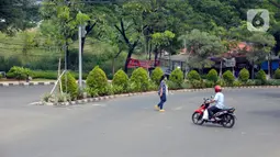 Seorang wanita berjalan pada hari ketiga penerapan PSBB Bundaran Ciater, Tangerang Selatan, Banten, Senin (20/04/2020). Pemberlakukan PSBB ini diharapkan bisa memutus penyebaran virus Covid-19 wilayah tangerang selatan dan sekitarnya. (merdeka.com/Dwi Narwoko)