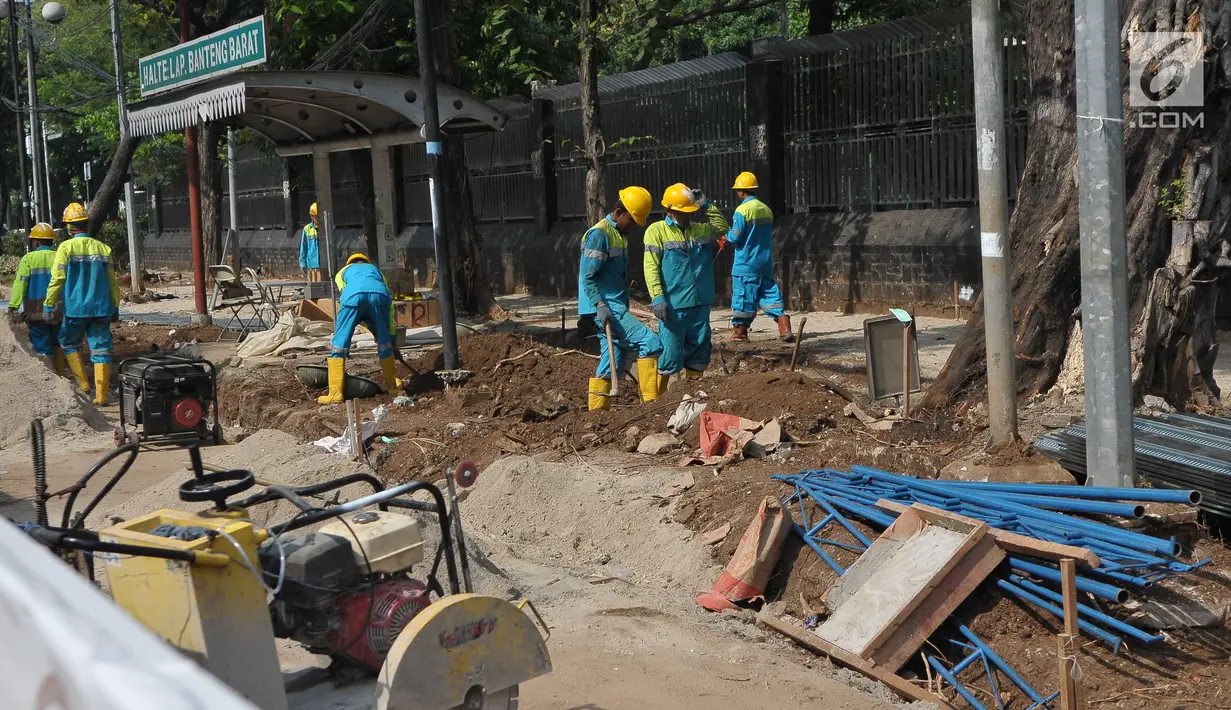 Pekerja menyelesaikan pembangunan pedestrian di Jalan Lapangan Banteng, Jakarta, Minggu (16/7). Pemprov DKI Jakarta menargetkan dapat membangun pedestrian sepanjang 45 kilometer per tahun. (Liputan6.com/Helmi Afandi)