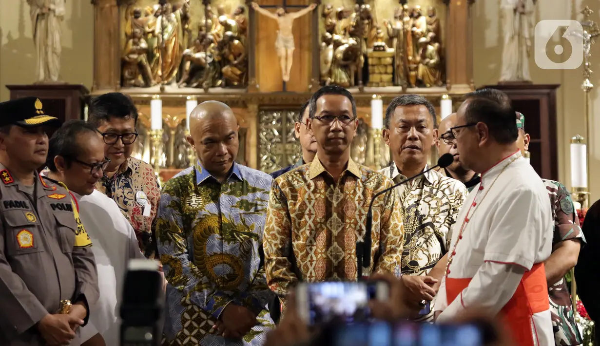 Penjabat (Pj) Gubernur DKI Jakarta, Heru Budi Hartono (tengah) berbincang bersama Pastor Kepala Gereja Katedral Jakarta, Albertus Hani Rudi Hartoko SJ, Jakarta, Sabtu (24/12/2022). Heru Budi ditemani Kapolda Metro Jaya, M Fadil Imran melakukan peninjauan ke gereja-gereja untuk memberi pesan damai dan toleransi di DKI Jakarta. (Liputan6.com/Helmi Fithriansyah)