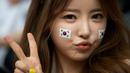Gaya menggemaskan dari fans cantik Korea saat laga Korea selatan kontra Rusia pada 18 juni 2014 (AFP PHOTO/Ed Jones)