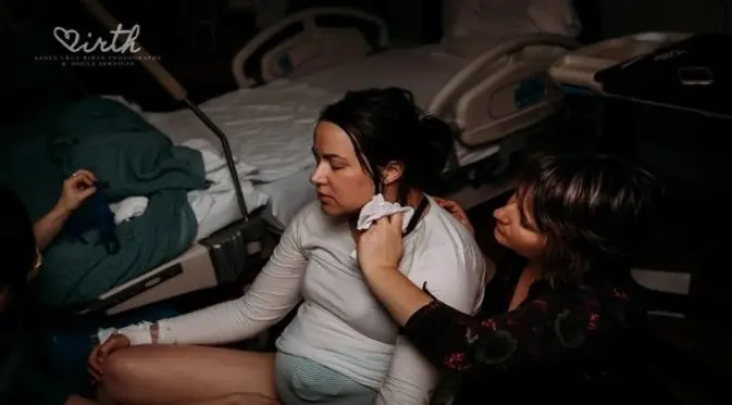 Pendamping persalinan sedang menyeka keringat. (Foto: Santa Cruz Birth Photography)