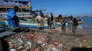 Nelayan Palestina mengumpulkan ikan sarden di pelabuhan Gaza City (26/5/2020). Menurut data statistik resmi Palestina, ada sekitar 3.800 nelayan bekerja menggunakan 700 lebih perahu, sementara ada sekitar 70.000 orang yang mencari nafkah dengan menangkap atau menjual ikan. (Xinhua/Rizek Abdeljawad)