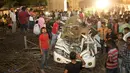 Warga India melihat sebuah mobil yang hancur tertimpa material jalan layang yang runtuh di Varanasi, Selasa (15/5). Jembatan layang itu masih dibangun ketika sebagian struktur semennya jatuh ke jalan di bawahnya. (AP/Rajesh Kumar Singh)