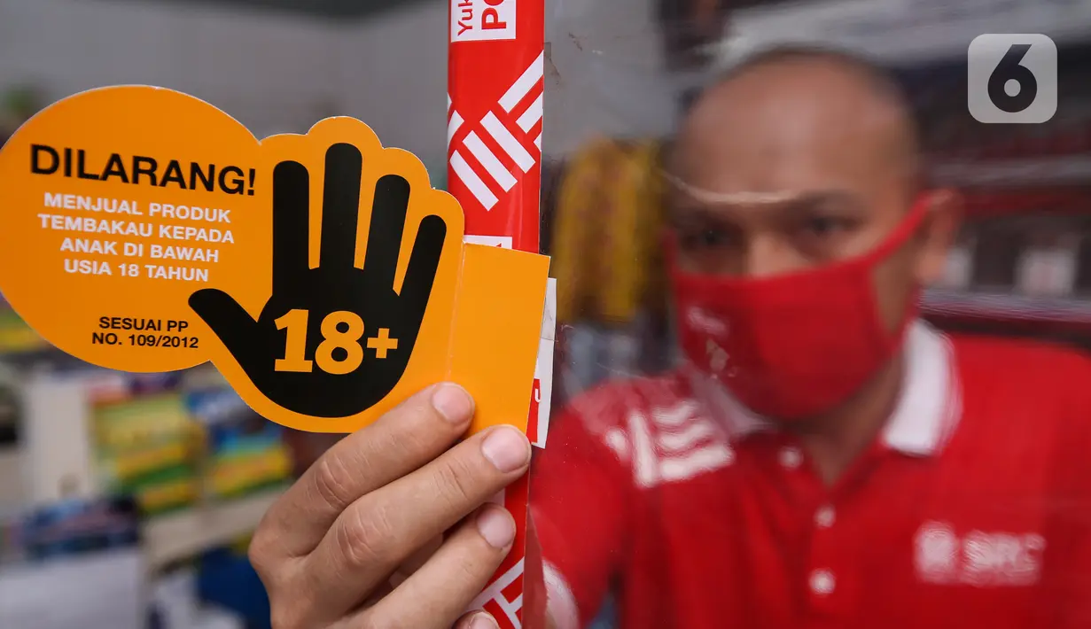 Pekerja toko kelontong “Sampoerna Retail Community (SRC) Salim” memasang materi sosialisasi PAPRA di Setiabudi Jakarta, Senin (16/11/2020). Progam PAPRA sejalan dengan komitmen Sampoerna untuk melakukan pemasaran produk tembakau sesuai dengan PP 109/2012. (Liputan6.com/Pool/SRC)