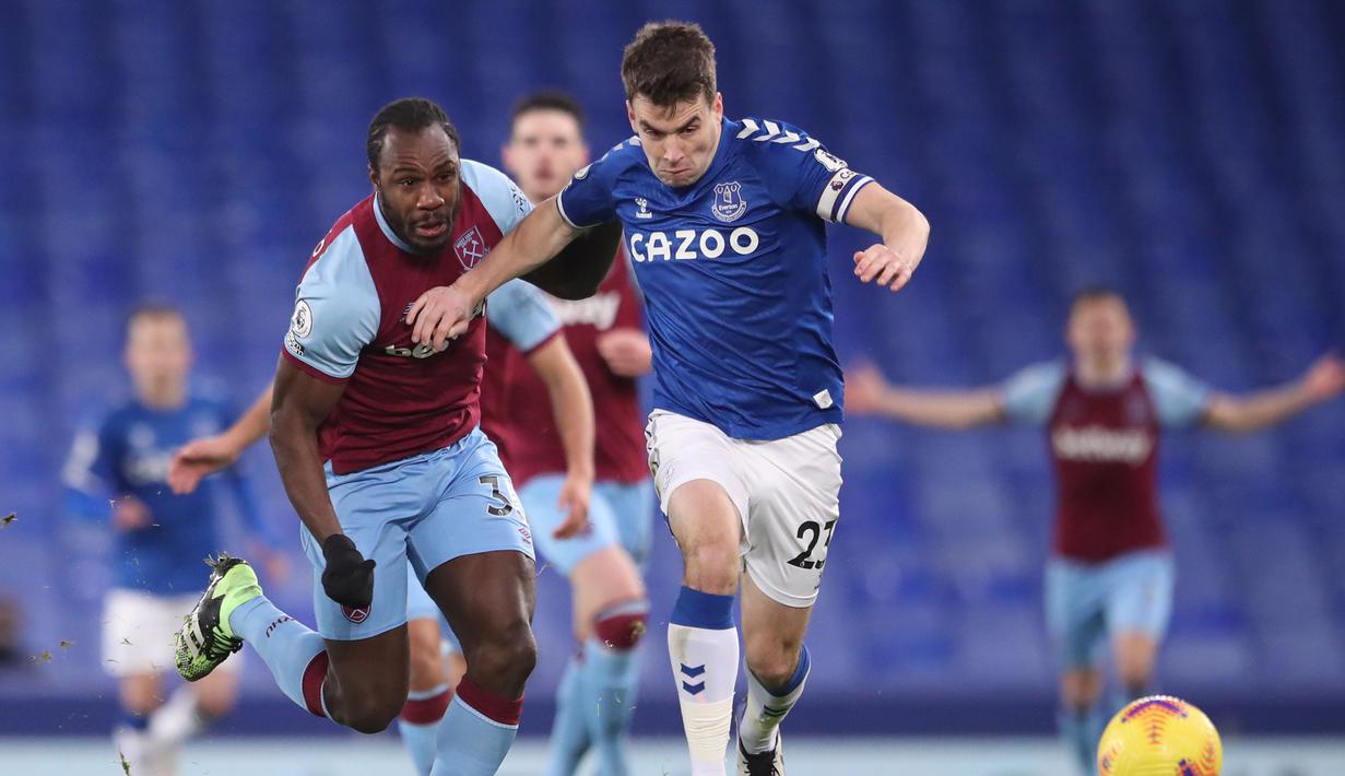 Bek Everton, Seamus Coleman (kanan) berebut bola dengan gelandang West Ham United, Michail Antonio dalam laga lanjutan Liga Inggris 2020/21 pekan ke-17 di Goodison Park, Jumat (1/1/2021). Everton kalah 0-1 dari West Ham United. (AFP/Alex Pantling/Pool)
