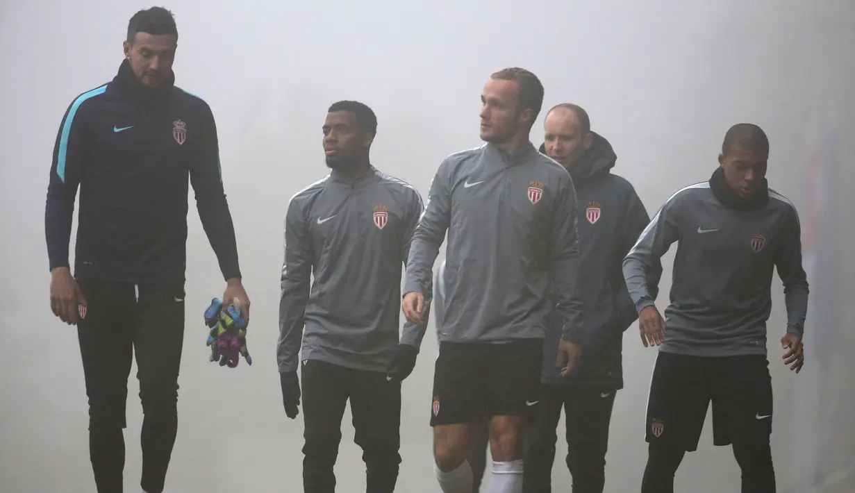 Para pemain AS Monaco berjalan saat kabut tebal menutupi tempat latihan tim AS Monaco jelang bertanding di Liga Champions di La Turbie, Prancis  (21/11). AS Monaco akan menjamu wakil Inggris Tottenham Hotspurs. (REUTERS/Eric Gaillard)