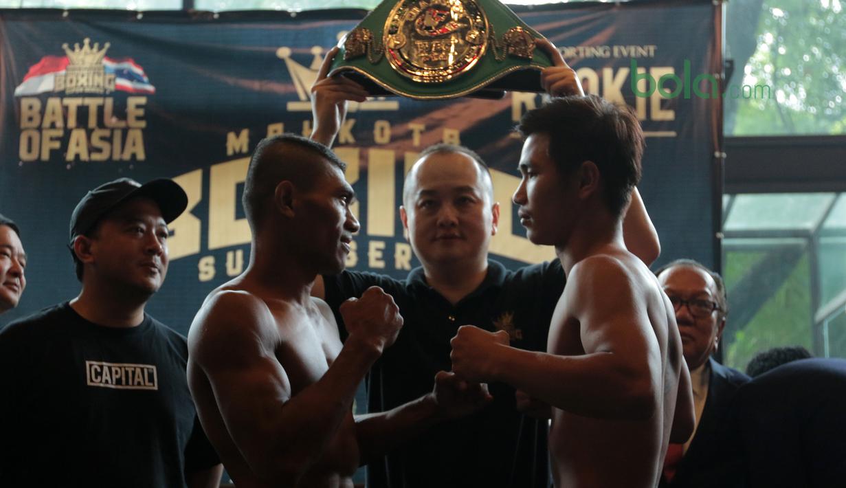 Eksprsi petinju Indonesia, Jansen Hebi Marapu (3kiri) dan lawannya petinju Thailand, Phuttinphong Rakoo saat timbang badan di Leon Restourant, Wijaya, Jakarta (09/3/2018). Jansen dan Rakoo bermain pada kelas Lightweight. (Bola.com/Nick Hanoatubun).
