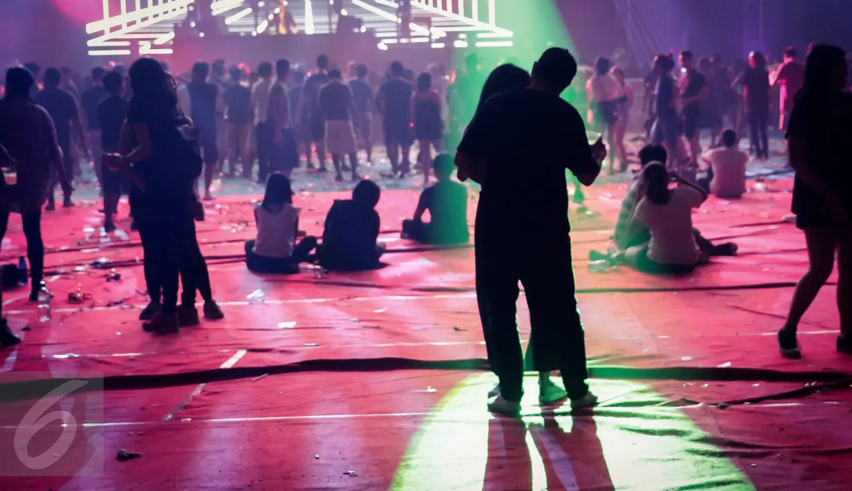 Sepasang kekasih mengikuti irama music DJ pada acara DWP 2016, di Kemayoran, Jakarta, Jumat. (09/12). Pengunjung dari berbagai negara memadati area JIExpo Kemayoran. (Liputan6.com/Fery Pradolo)