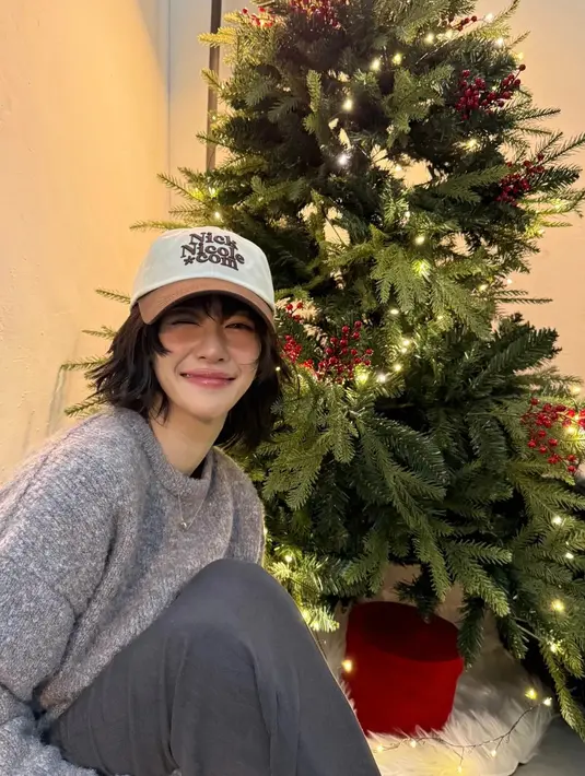 Seo Ye Ji berfoto dengan pohon Natal yang tidak terlalu penuh ornamen. Ia pun tampil mengenakan knit abu-abu dan topi cap coklat. [@yeyeji_seo]