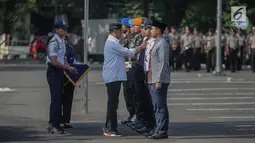 Menteri Perhubungan Budi Karya memberikan plakat kepada petugas saat apel persiapan pengamanan dan angkutan lebaran 2019 di Stasiun Gambir, Jakarta, Minggu (26/5/2019). Hal itu terbukti bahwa penjualan tiket kereta api untuk perjalanan H-7 hingga H+7 sudah laku terjual. (Liputan6.com/Faizal Fanani)