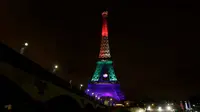 Lampu berwarna pelangi menerangi Menara Eiffel di Paris pada Senin (13/6/2016)  malam. Menara yang terkenal dengan romantisme itu memberikan penghormatan untuk korban penembakan brutal di klub malam gay di Orlando, Florida AS. (Thomas SAMSON/AFP)