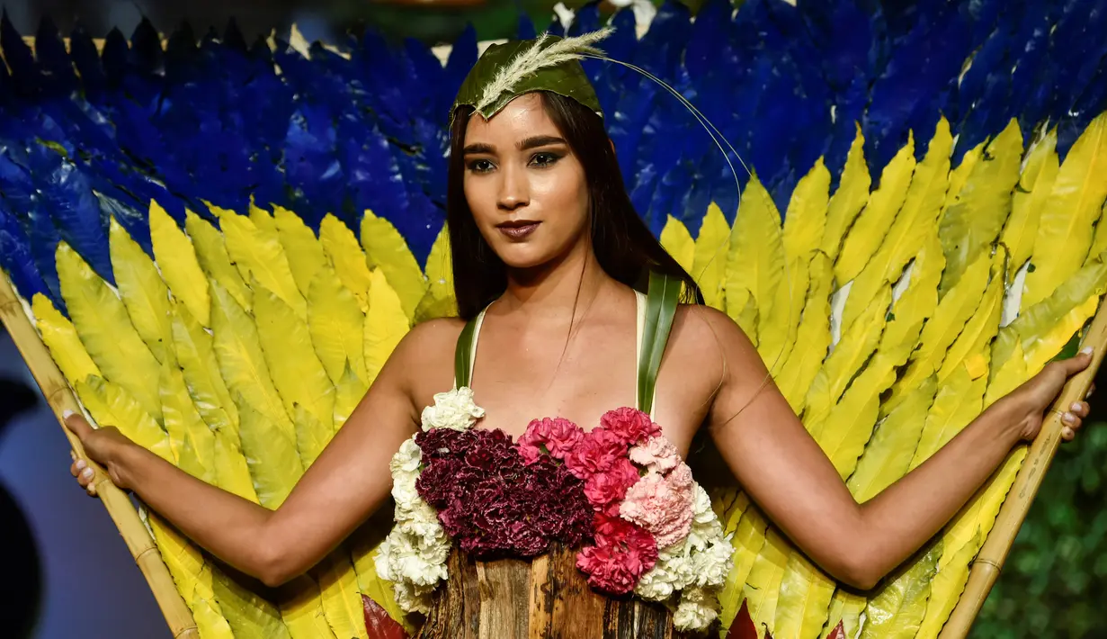 Seorang model memperagakan busana rancangan desainer Kolombia, Camila Gonzale selama BioFashion Show di Cali  pada 17 November 2018. Ajang ini menampilkan gaun-gaun unik yang terbuat dari tanaman hidup, bunga dan unsur organik lain. (Luis ROBAYO/AFP)