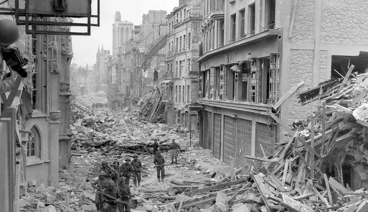 Pasukan Kanada terlihat berpatroli di sepanjang Rue Saint-Pierre, Caen yang hancur pada Juli 1944 silam. (National Archives of Canada)