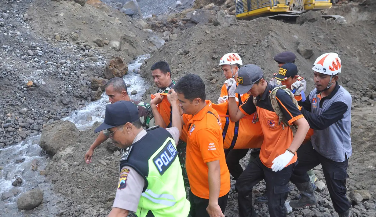 Petugas mengevakuasi korban tanah longsor di Magelang, Senin (18/12). Menurut pejabat setempat, delapan penambang tewas akibat longsor di lereng gunung berapi di pulau Jawa. (AFP Photo)