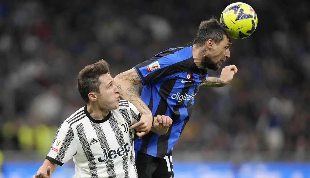 Pemain Inter Milan, Francesco Acerbi, duel udara dengan pemain Juventus, Federico Chiesa, pada laga Coppa Italia di Stadion Giuseppe Meazza Kamis (27/04/2023). (AP Photo/Luca Bruno)