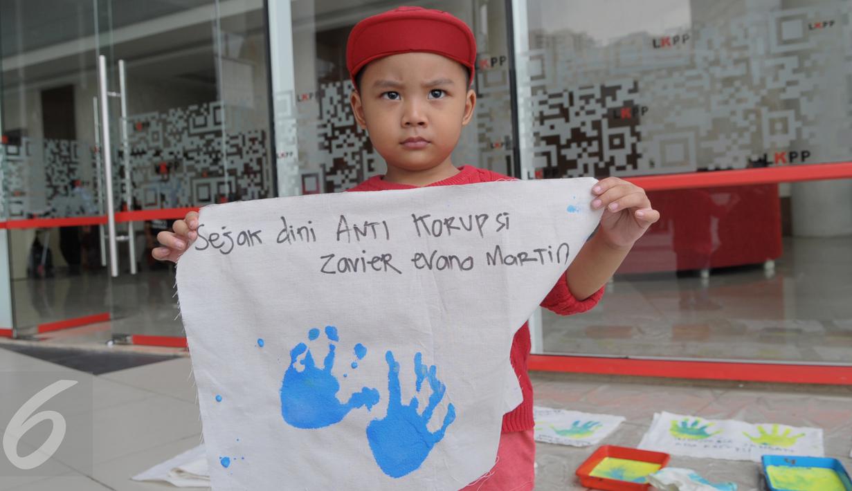 Seorang bocah memegang spanduk bertuliskan anti korupsi saat acara peringatan anti korupsi 2015 LKPP, KPK, dan ICW bertajuk Hackathon Merdeka 3.0, Di LKPP Tower kawadan Rasuna Sahid, Jakarta, Sabtu (05/12). (Liputan6.com/Faisal R Syam)