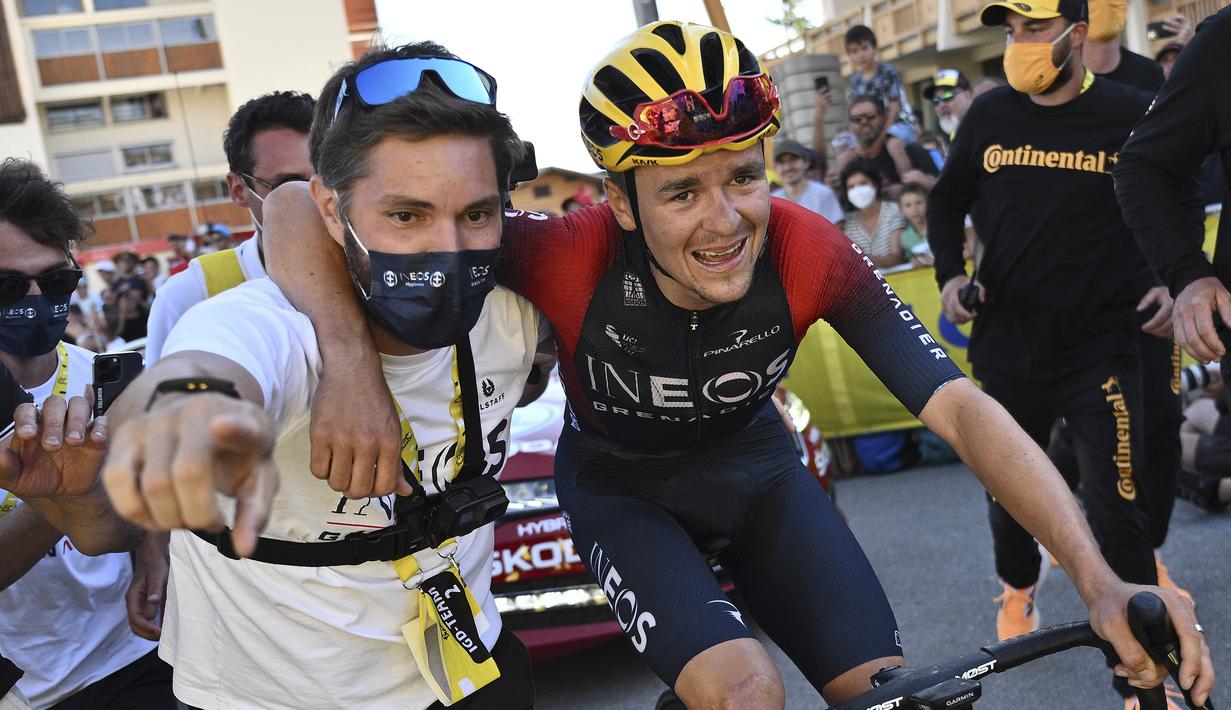 Pebalap tim Ineos Grenadiers, Thomas Pidcock (kanan) dibantu rekan timnya usai melintasi garis finis pada Stage 12 Tour de France 2022 yang menempuh rute sepanjang 165,1 km dari Briancon hingga L'Alpe-d'Huez, di Pegunungan Alpen, Prancis, Jumat (14/07/2022). (AP/Thibault Camus)