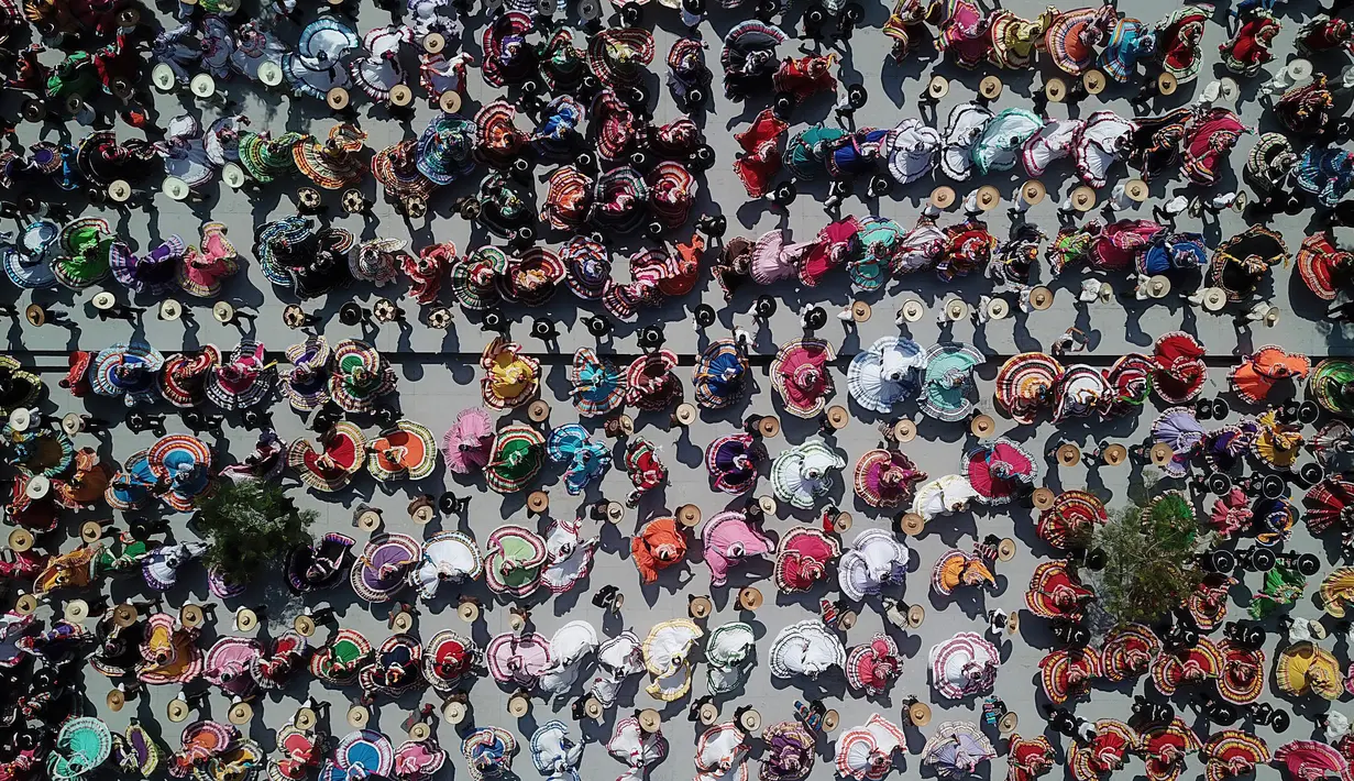 Pandangan udara pasangan menari mengikuti irama musik mariachi untuk memecahkan Rekor Dunia Guinness di Guadalajara, Meksiko, 24 Agustus 2019. Sebanyak 882 orang menari dengan kostum tradisional dalam upaya memecahkan rekor dunia untuk kategori tarian rakyat terbesar. (ULISES RUIZ/AFP)