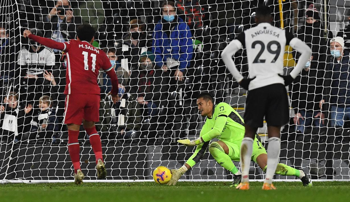 Striker Liverpool, Mohamed Salah, melakukan eksekusi penalti yang gagal dibendung kiper Fulham, Alphonse Areola, dalam laga lanjutan Liga Inggris 2020/21 pekan ke-12 di Craven Cottage, Minggu (13/12/2020). Liverpool bermain imbang 1-1 dengan Fulham. (AFP/Neil Hall/Pool)