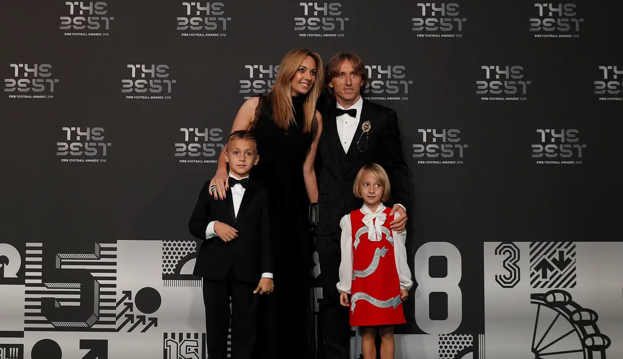Gelandang Real Madrid yang juga Kapten Timnas Kroasia, Luka Modric berpose bersama istrinya, Vanja serta anak-anak mereka Ivano dan Ema setibanya dalam acara The Best FIFA Football Awards di Royal Festival Hall, London, Senin (24/9). (Adrian DENNIS / AFP)