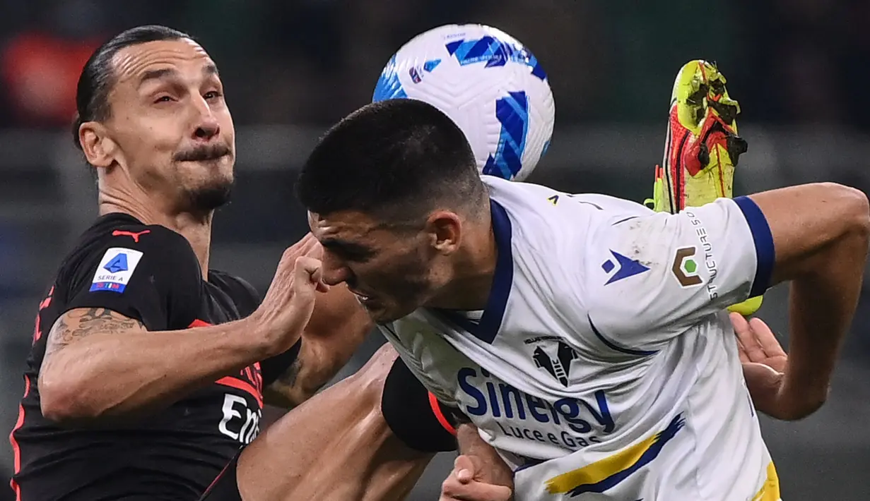 Penyerang AC Milan, Zlatan Ibrahimovic (kiri) berebut bola dengan bek Hellas Verona, Bosko Sutalo pada pekan kedelapan Liga Italia 2021/2022 di San Siro, Minggu (17/10/2021) dini hari WIB. AC Milan menang dramatis atas Hellas Verona 3-2. (Marco BERTORELLO / AFP)