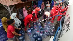 Petugas Palang Merah Indonesia (PMI) mengisi air bersih ke dalam galon air milik warga di RW 08. Cipayung Jaya, Kota Depok, Jawa Barat, Jumat (14/07/2026).