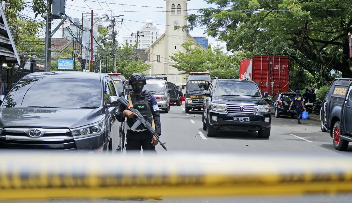 Petugas polisi berjaga di dekat gereja tempat ledakan meledak di Makassar, Sulawesi Selatan (28/3/2021). Kabid Humas Polda Sulawesi Selatan Kombes E Zulpan menyebut ada korban tewas dalam insiden ledakan Gereja Katedral Makssar, Sulawesi Selatan, Minggu (28/3) pagi. (AP Photo/Daeng Mansur)