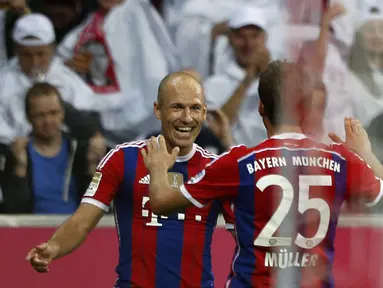 Arjen Robben dan Thomas Mueller, merayakan gol kemenangan Bayern Munich atas Wolfsburg 2-1 di Allianz Arena, (23/8/2014). (REUTERS/Michaela Rehle)