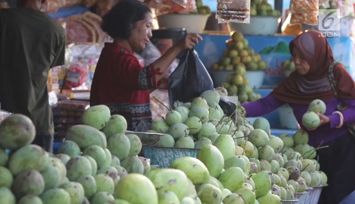 Pembeli memilih buah mangga yang dijajakan oleh pedagang di warung tepi jalan kawasan Jalur Pantura Indramayu, Jawa Barat, Kamis (29/6). Buah mangga memang sudah menjadi ciri khas dan oleh-oleh khas Indramayu. (Liputan6.com/Helmi Afandi)
