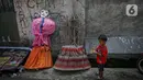 Seorang anak berada di dekat ondel-ondel di Kramat Pulo, Jakarta, Senin (7/6/2021). Jelang HUT DKI Jakarta ke-494, jumlah permintaan kesenian ondel-ondel meningkat. Eksistensinya pun masih terjaga hingga kini. (Liputan6.com/Faizal Fanani)