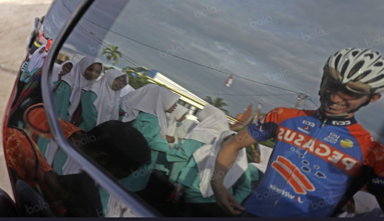 Refleksi pebalap Pegasus Cycling Team dan anak-anak sekolah saat Tour de Singkarak 2016 pada start di Sijunjung, Sumatera Barat, Jumat (12/8/2016). (Bola.com/Nicklas Hanoatubun)