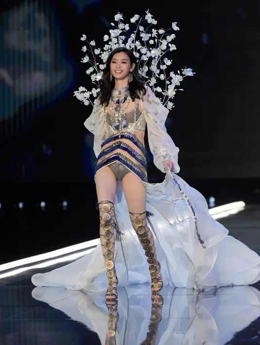Model Tiongkok, Ming Xi berjalan di atas catwalk memperagakan koleksi lingerie pada Victoria’s Secret Fashion Show 2017 di Shanghai, Senin (20/11). Ming sempat tergelincir dan jatuh tersungkur di catwalk. (FRED DUFOUR/AFP)