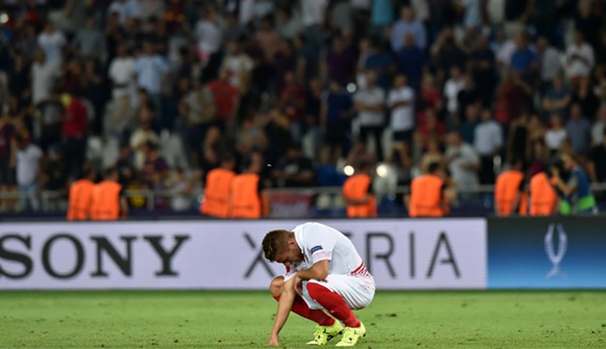 Pemain Sevilla, Ciro Immobile tertunduk usai kalah melawan Barcelona pada laga UEFA Super Cup di Tbilisi, Georgia, Selasa (11/8/2015). Bercelona menang 5-4 atas Sevilla. (AFP Photo/Kirill Kudryavtsev)