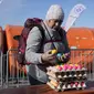 Pengungsi perempuan mengambil telur rebus berwarna setelah melarikan diri dari perang di perbatasan di Medyka, Polandia tenggara, Minggu (27/3/2022). Lebih dari 3,7 juta orang telah melarikan diri dari invasi Rusia sejauh ini, eksodus terbesar di Eropa sejak Perang Dunia II. (AP Photo/Sergei Grits)