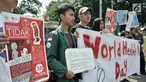 Mahasiswa Universitas Muhammadiyah Prof. Dr. Hamka membentangkan spanduk saat menggelar kampanye bahaya merokok di car free day (CFD), Jakarta, Minggu (8/4). Kampanye digelar untuk memperingati Hari Kesehatan Dunia. (Merdeka.com/Iqbal Nugroho)